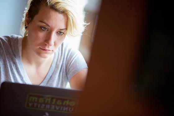 图为一位网上赌博平台的学生在咖啡厅里看着她的笔记本电脑.