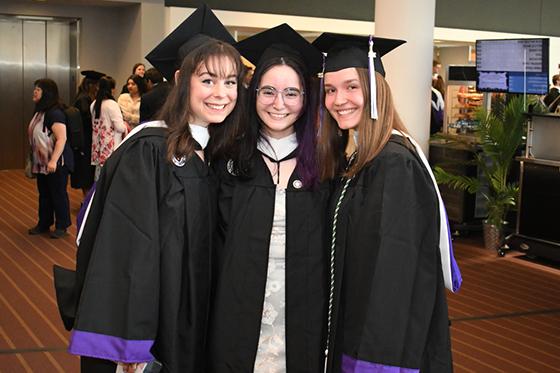 图为三名年轻的网上赌博平台女学生身穿毕业袍，头戴毕业帽，摆姿势拍照