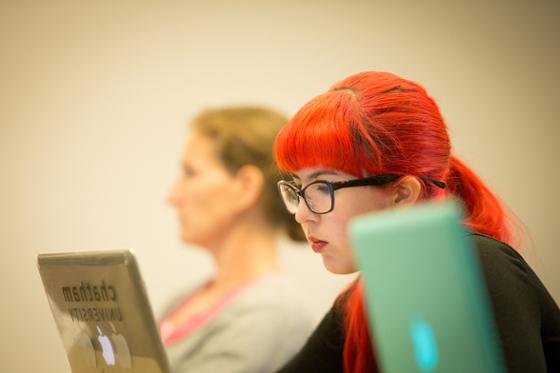 图为英国网上赌博平台的一名女学生在讲课时在笔记本电脑上写字.