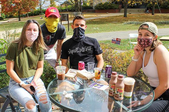 四名网上赌博平台的学生戴着口罩，在网上博彩平台外面一起闲逛
