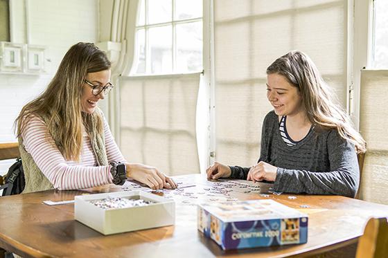 图为两名网上赌博平台的学生在休息室的桌子上玩拼图游戏