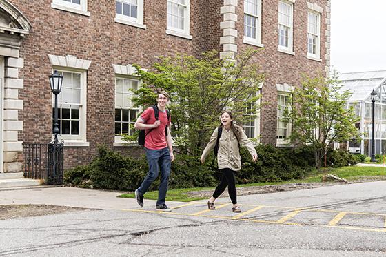 Photo of two Chatham University students crossing a street on Shadyside Campus