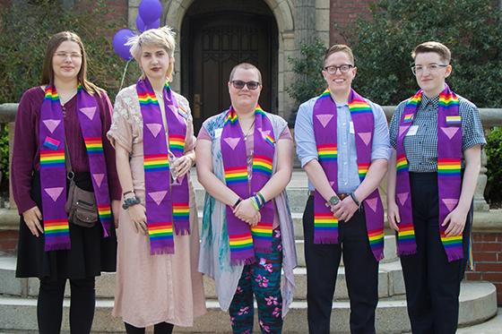图为一群英国网上赌博平台的学生穿着印有彩虹LGBTQ+图案的毕业礼服, 一起摆姿势拍照. 